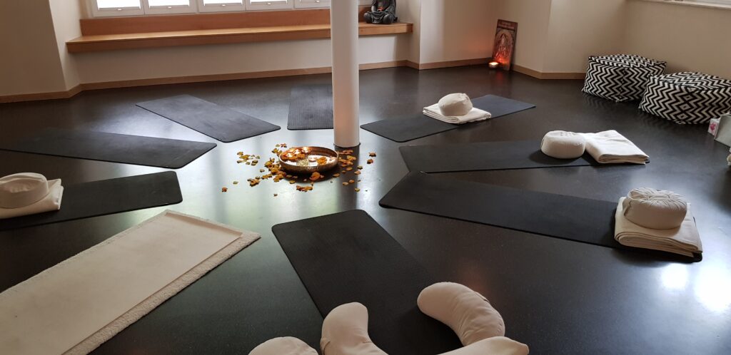 Sternförmig angeordnete Yogamaten im Kursraum